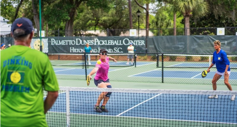 Two women and man playing pickleball Palmetto Dunes Hilton Head pickleball on vacation